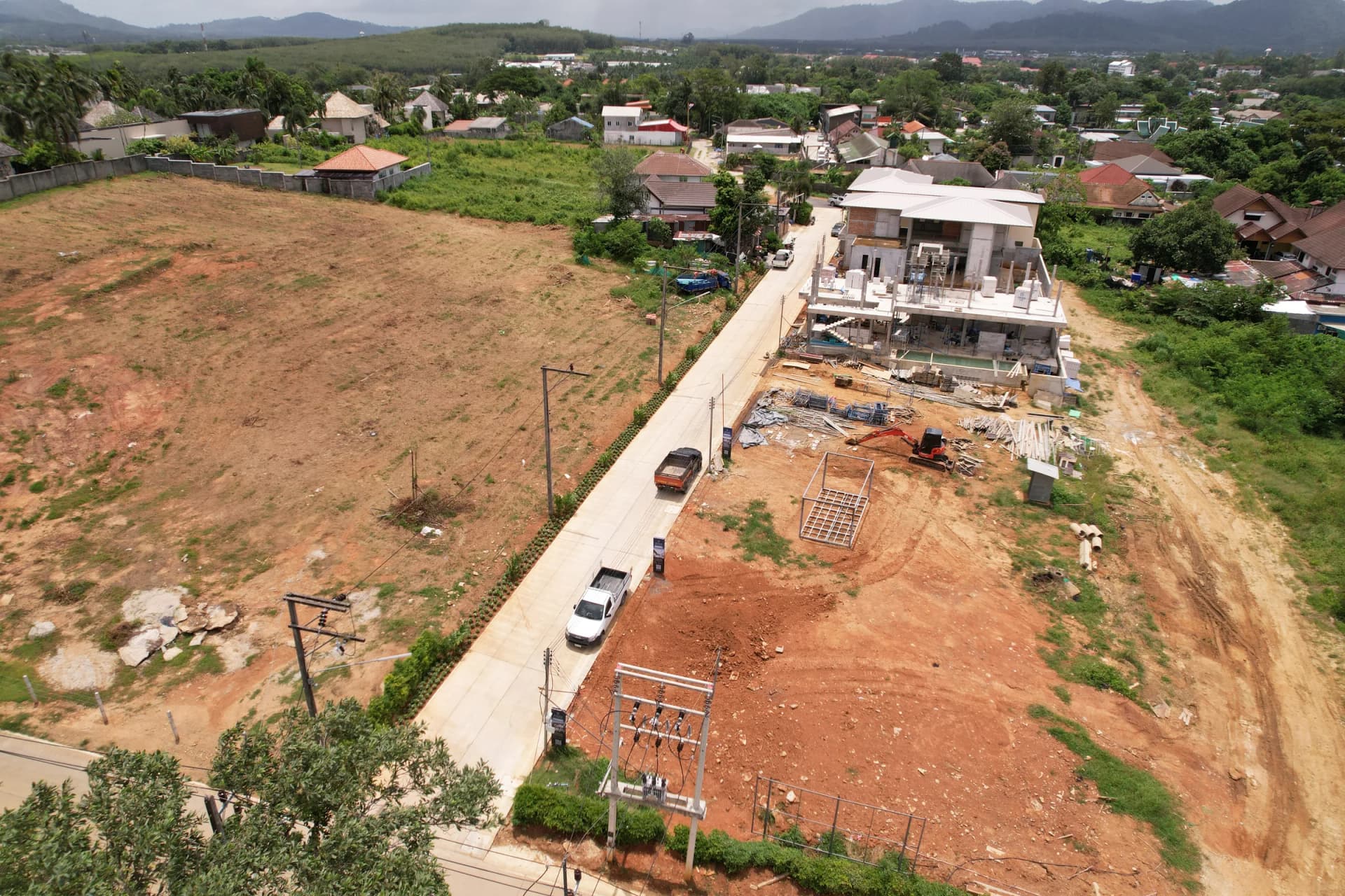 Drone, 14 Aug 2026: the concreted lane, the finished show villa and the plots below